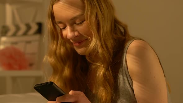 Cheerful Female Teenager Chatting With Boyfriend on Smartphone First Love