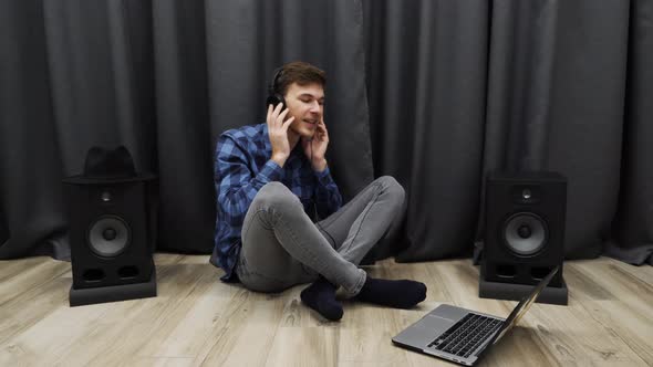 Young Man puts on headphones and sings a song moving his body with beat. Singer practicing vocals