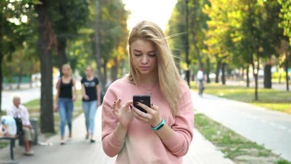 Girl Is Using Smartphone on Street