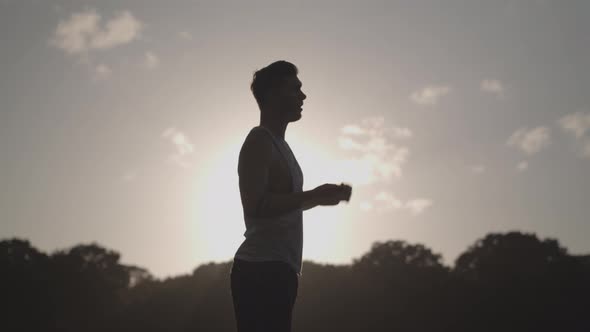 Man Stretchs In Park Before He Works Out - Ungraded