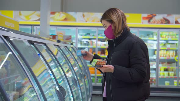 Woman Wearing a Face Mask to Protect Covid19 Standing in Front of Shelves in Refrigerated