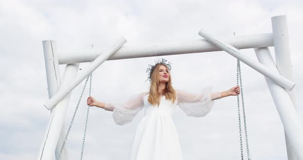 a Bride in a Festive White Dress Swings on a Swing in a Lavender Field