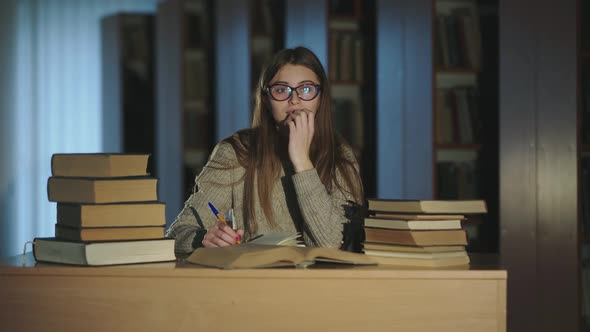 Girl in Smiling at Camera and Having a Fun During Noting a Compendium From Books