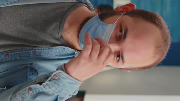 Vertical Video Portrait of Man Putting on Protection Mask Looking at Camera