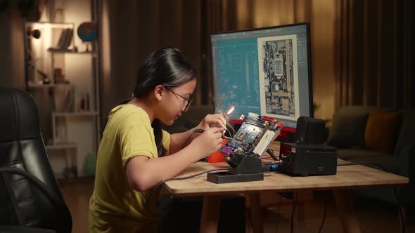 Girl Is Soldering Electronic Circuit And Works With Computer In Home, Display Showing Cad Software