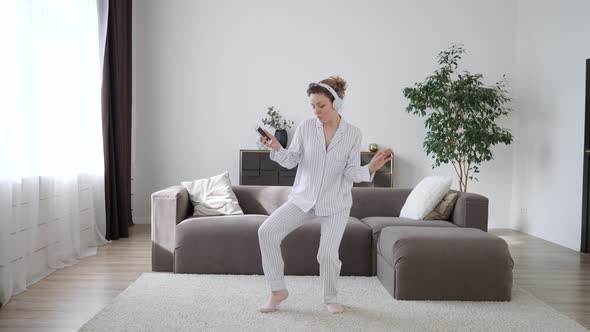 Happy Woman Singing And Dancing With Headphones At Home, Having Fun.