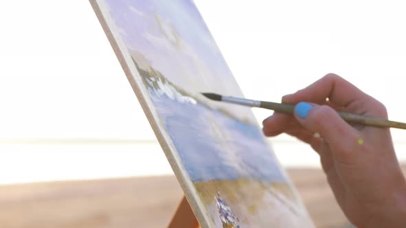 Young Woman Artist Painting Landscape in the Open Air on the Beach Close Up