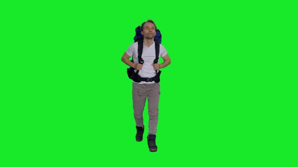 Front View of Hiker Man with Backpack Going Camping in Nature against Green Screen