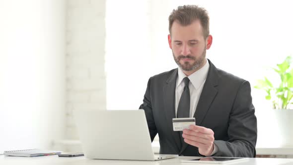 Young Businessman Making Online Payment Failure on Laptop in Office