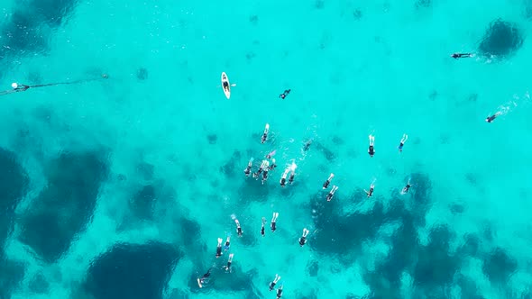 Unique high view of snorkelers drifting across the tropical coloured waters of the Great Barrier Ree