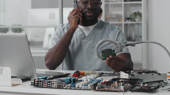 Electronics Engineer Speaking on Phone at Work in Laboratory