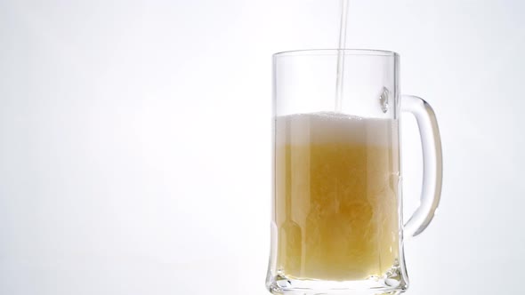 Beer Pouring Into Glass on White Background