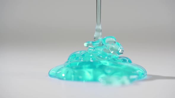 DETAILED: Turquoise Gel Pouring on the Table. Light White Room. 4-x Slow Motion.