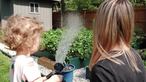 Mom and Daughter to Spray Plants with Water Working Together Agriculture Care