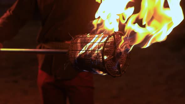 Man Holding Fire Stick with Flame on Net