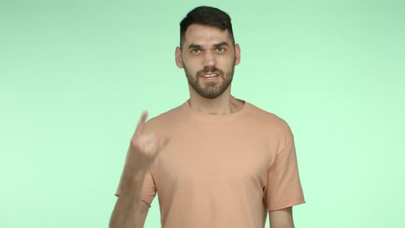 Cheerful Handsome Man with Beard Wearing Summer Tshirt Showing Rocknroll Horns and Saying Yeah