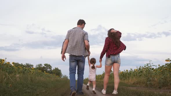 Little Daughter Jumping Holding Hands Mom and Dad