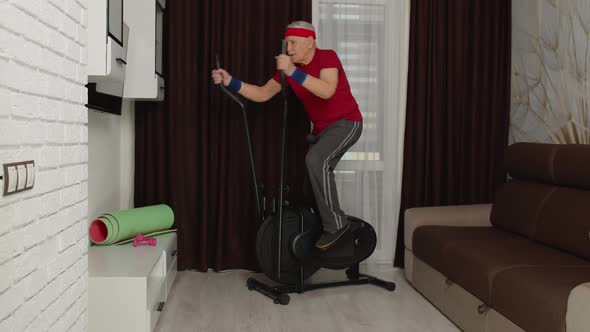 Senior Man Using Orbitrek with Fitness Exercises in Living Room at Home During Coronavirus Lockdown