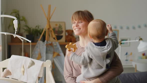 Cheerful Mother Bonding with Baby in Kids Room