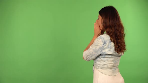 A Young Beautiful Caucasian Woman Cheers As She Faces the Green Screen Background