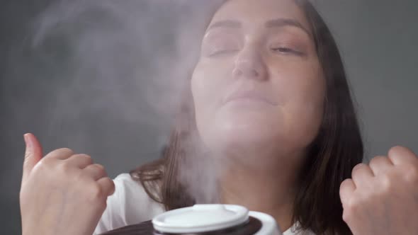 Brunettehaired Woman Enjoying Moist Air From Humidifier