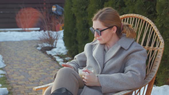 Woman In Rocking Chair With Coffee