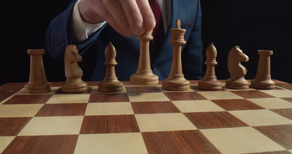 Businessman Playing Chess Game Moving White Queen on Board