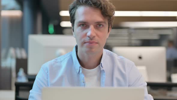 Close Up of Man Shaking Head As Yes Sign While Using Laptop