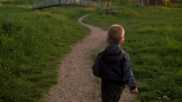 Authentic Cute 1 Little Preschool Baby Boy Walking and Run Along Path in Park on Tall Grass at