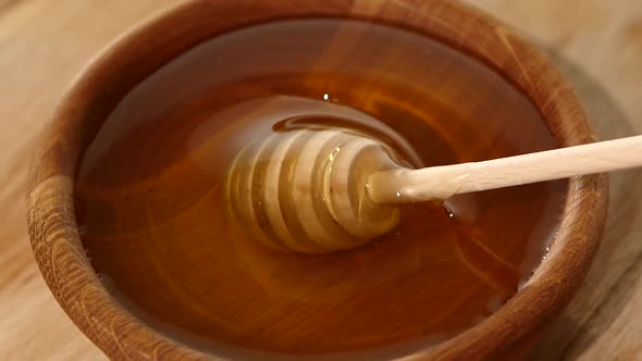 Using Spoon for Honey in Wooden Bowl, Twisting, Slow Motion