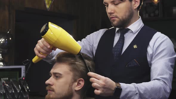 Young Handsome Man Getting His Hair Dried By a Barber