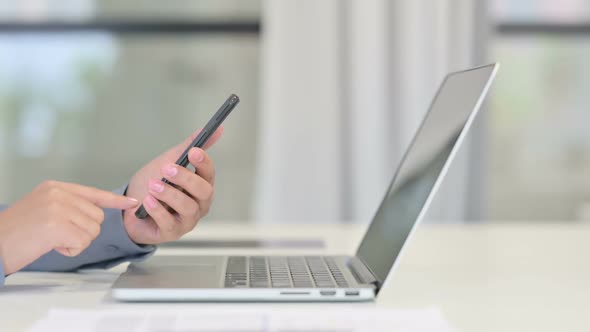 Close Up of African Woman with Laptop Using Smartphone