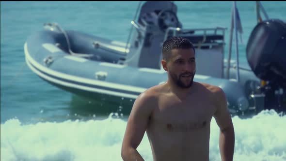 Young Handsome Man Runs on Sea Water To the Camera