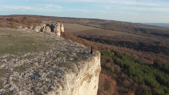 Woman standing at the edge of stunning rock