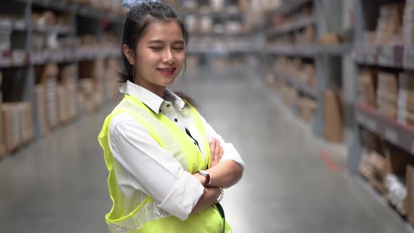 Portrait of the Beautiful Asian Female Worker Standing and Smiling Charmingly in storage warehouse