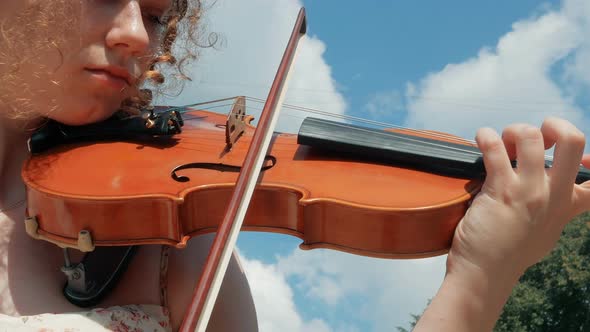 young curly blond woman the violinist: Musician playing violin