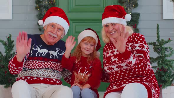 Senior Old Couple Grandparents with Grandchild Girl Kid Waves Hand Hello Hi Near Christmas House