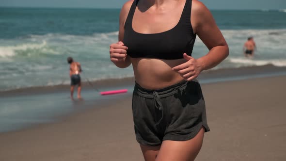 Unrecognizable Lady is Jogging Along Sandy Beach of a Sea