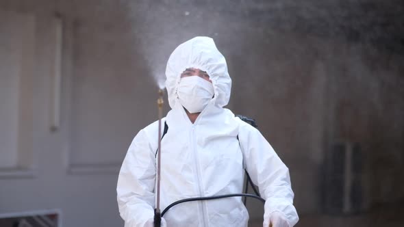 Worker in a Protective Suit Disinfects Surfaces From Coronavirus. Antibacterial Sanitary Measures on