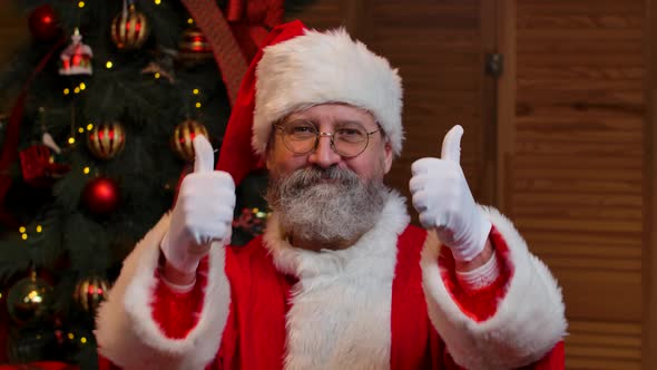 Portrait of Santa Claus Looking Into the Camera Showing Thumbs Up Gesture