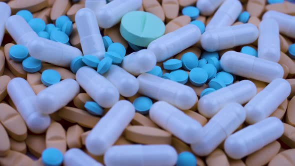 Bright Multi-colored Painkillers White Capsules Lie Together. Close Up Rotation