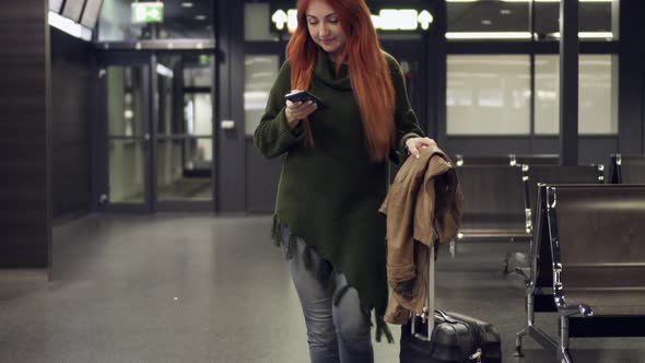 Woman Browsing Online on Smartphone in Night Airport