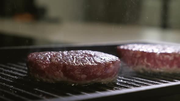 Delicious meat for burger is fried in grill pan in home kitchen.