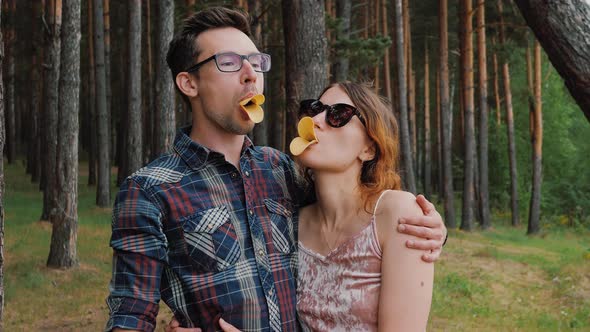 Couple in Love Hugs Cheerfully Plays with Each Other Outdoors Kissing Lips with Chips