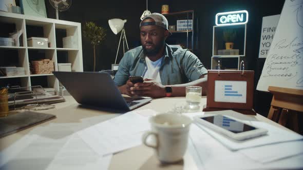 Focused African American Businessman Looking Computer in Modern Office.