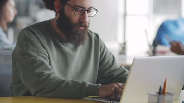 Young Bearded Man Posing for Camera at Office Workplace