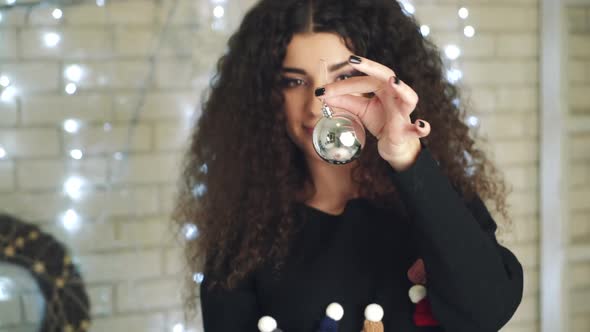 Girl holding Christmas toy. Young woman holding toy for decorating Christmas tree at home