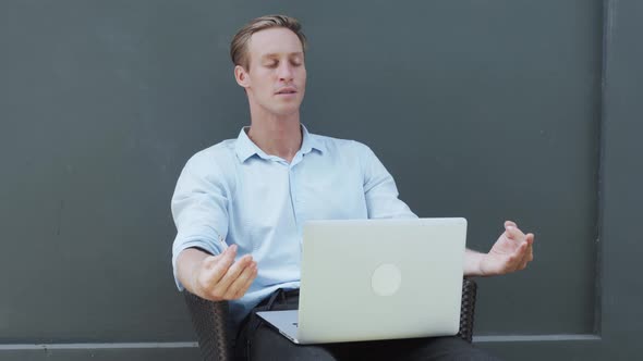 Man Meditates Looks at Laptop Screen Smokes Nervously Gray Wall on Background