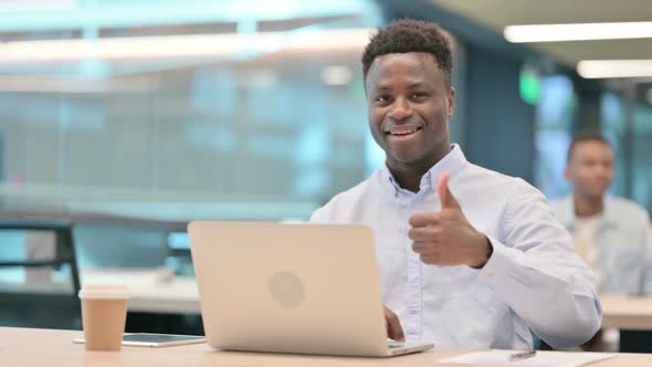 Thumbs Up By African Businessman with Laptop at Work