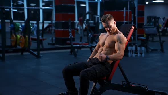 Athletic man doing exercises with dumbbell at biceps